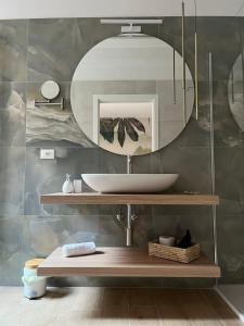 een badkamer met een wastafel en een spiegel bij CALARI ROOMS - AFFITTACAMERE in Bologna