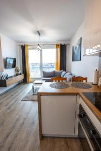 a kitchen and a living room with a couch at Apartament Sunny Five in Suwałki