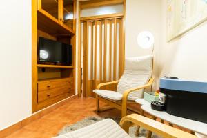 a living room with a chair and a tv at CAMBARAL 1E in Luarca