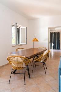 uma sala de jantar com uma mesa de madeira e cadeiras em Villa Torre di Lupo- Manfredi Homes&Villas em Mattinata