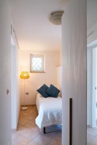 um quarto com uma cama com almofadas azuis e uma janela em Villa Torre di Lupo- Manfredi Homes&Villas em Mattinata