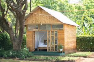 Mkoani Homestay في موشي: كوخ خشبي صغير فيه سرير