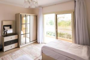 a bedroom with a bed and a large window at Villa X15-11 Grand Heights in 6th Of October