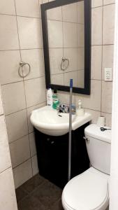 a bathroom with a sink and a toilet and a mirror at Appartement 2 Chambre neuf in Longueuil