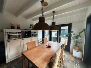 a kitchen with a wooden table and some chairs at De Waddenparel in Kinnum