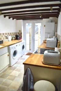 a kitchen with a washer and dryer in it at Angel Cottage in Bishopsteignton