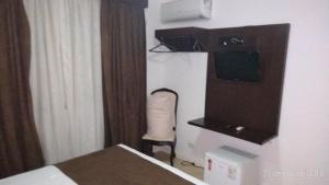 a hotel room with a bed and a television at Suíte em Hotel Cotia in Vargem Grande Paulista