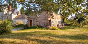 an old stone house in a grassy field at Le Lodge de Loge & Broc in La Possonnière