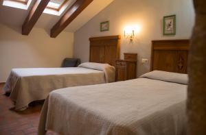a room with two beds and a chair in it at El Lagar del Vero in Huerta de Vero