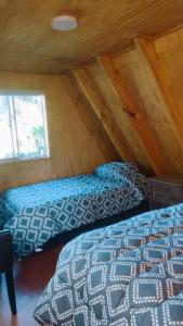 a bedroom with two beds in a attic at Travesía Rukamanque Lodge in Temuco