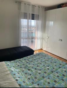 ein Schlafzimmer mit einem Bett und einem großen Fenster in der Unterkunft La casa di LUCA in Imola