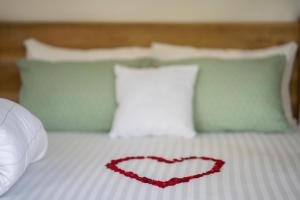a red heart on a bed with pillows at Mkoani Homestay in Moshi