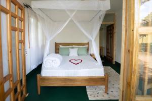 a bedroom with a bed with a heart on it at Mkoani Homestay in Moshi