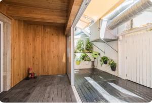 une pièce vide avec une porte en bois et des plantes en pot dans l'établissement Sintra Design Apartment _ Castelo dos Mouros, à Sintra