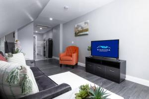 a living room with a couch and a television at Cozy Micro apartment Sleeps 2-3, Minutes from Falls in Niagara Falls