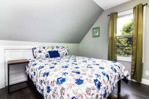 um quarto com uma cama com um edredão azul e branco em Cozy Micro apartment Sleeps 2-3, Minutes from Falls em Niagara Falls