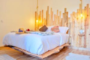 sypialnia z łóżkiem wykonanym z drewna w obiekcie MAMA,3 min à la plage10 min à la médina w mieście As-Suwajra