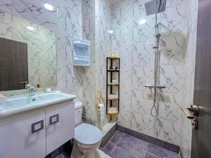 een badkamer met een douche, een toilet en een wastafel bij MAMA,3 min à la plage10 min à la médina in Essaouira