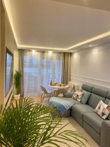een woonkamer met een bank en een tafel bij Luxury Appartement with terasse - 15mn from Champs-Elysée in Courbevoie