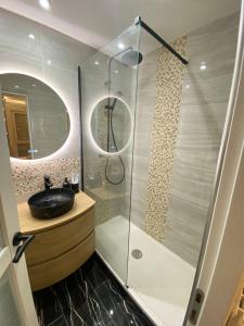 een badkamer met een wastafel en een glazen douche bij Luxury Appartement with terasse - 15mn from Champs-Elysée in Courbevoie