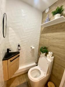 een badkamer met een wit toilet en een wastafel bij Luxury Appartement with terasse - 15mn from Champs-Elysée in Courbevoie