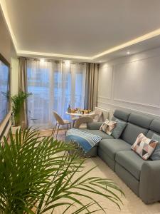 een woonkamer met een blauwe bank en een tafel bij Luxury Appartement with terasse - 15mn from Champs-Elysée in Courbevoie