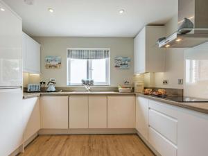 a kitchen with white cabinets and a window at 2 Bed in Westward Ho 73566 in Westward Ho