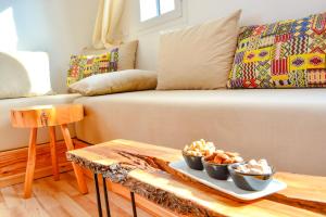 a living room with a couch with bowls of food on a table at MAMA,3 min à la plage10 min à la médina in Essaouira