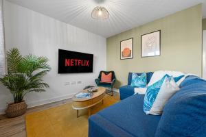 a living room with a blue couch and a table at Stylish 4-Bedroom Townhouse with two large parking spaces and superfast Wi-Fi in Gloucester +28 photos