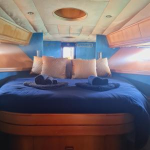 una cama en el medio de una habitación en Nuit insolite bateau à quai - Port Saint Louis du Rhône, en Port-Saint-Louis-du-Rhône