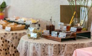 a table with two tables with desserts and jars of food at AQUARIUS HOTEL in Vasilikos