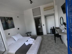 ein Wohnzimmer mit einem weißen Sofa und einem Schreibtisch in der Unterkunft Petteo Serifos in Livadakia