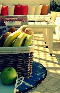 una cesta de plátanos y manzanas sobre una mesa en La Maison Kalogera, en Mykonos ciudad