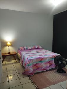 1 dormitorio con 1 cama y 1 mesa con lámpara en Aero Hostel en Londrina