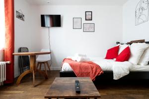 - un salon avec un lit et des oreillers rouges dans l'établissement The Nice Place proche Paris et Disney, à Neuilly-sur-Marne