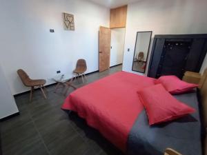 a bedroom with a large red bed with two red pillows at Suite Departamento Nuevo in Aguascalientes