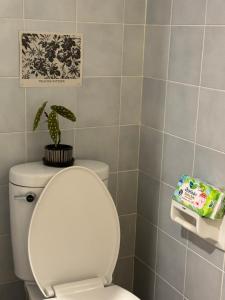 a bathroom with a toilet with a plant on top of it at Sandra’s sweet home in Chiang Mai
