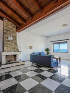 a living room with a blue couch and a fireplace at Ixia Aqua Vista House in Rhodes Town