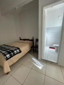 1 dormitorio con 1 cama y baño con lavamanos en Hotel Boa Vista en Matipó