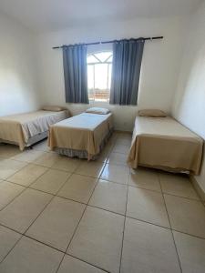 Zimmer mit 2 Betten und einem Fenster in der Unterkunft Hotel Boa Vista in Matipó