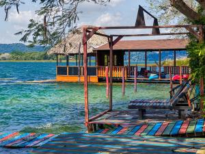 un complexe sur l'eau avec une terrasse dans l'eau dans l'établissement Las Luciernagas Hotel Boutique, à Flores