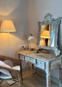 a dressing table with a mirror and two lamps on it at Masia Quelet in La Vall de Bianya