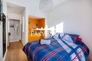 - une chambre dotée d'un lit avec une couverture bleue et rouge dans l'établissement Nice 5-bedroom apartment like a house, Boulogne, by Easyflat, à Boulogne-Billancourt