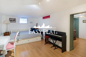 - une chambre avec un lit et un piano dans l'établissement Nice 5-bedroom apartment like a house, Boulogne, by Easyflat, à Boulogne-Billancourt