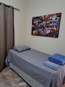 uma cama num quarto com uma pintura na parede em Ecohouse - Próx da Av Brasil em Franca