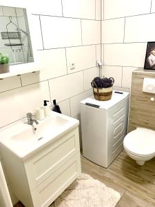 a white bathroom with a sink and a toilet at Stadtbude 50 in Emden