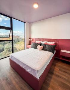 een slaapkamer met een groot bed en een groot raam bij Chic & Stylish: Prime Apartment in La Sabana, Your Ideal Urban Oasis Awaits in Uruca