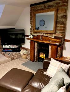 a living room with a couch and a fireplace at Angel Cottage in Bishopsteignton