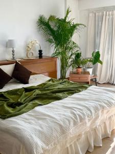ein Schlafzimmer mit einem großen Bett mit Pflanzen drauf in der Unterkunft Sandra’s sweet home in Chiang Mai