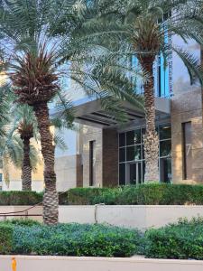 two palm trees in front of a building at Downtown Oasis, Burj Khalifa Views, Luxury Amenities in Dubai